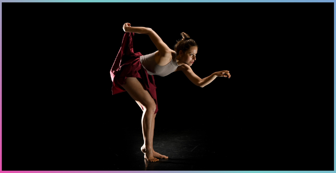 An image of a female solo dancer on stage bending forward in a pose