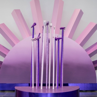A purple coloured stand with multiple glittery microphones.