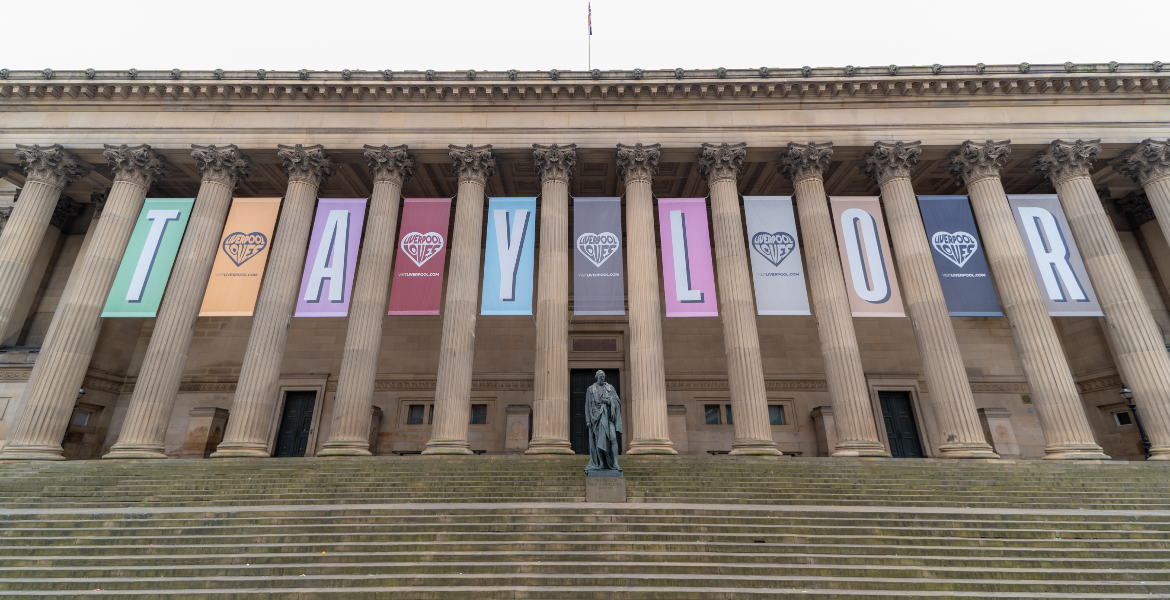 View of St George's Plateau, Liverpool with large colorful banners spelling "TAYLOR" between the columns.