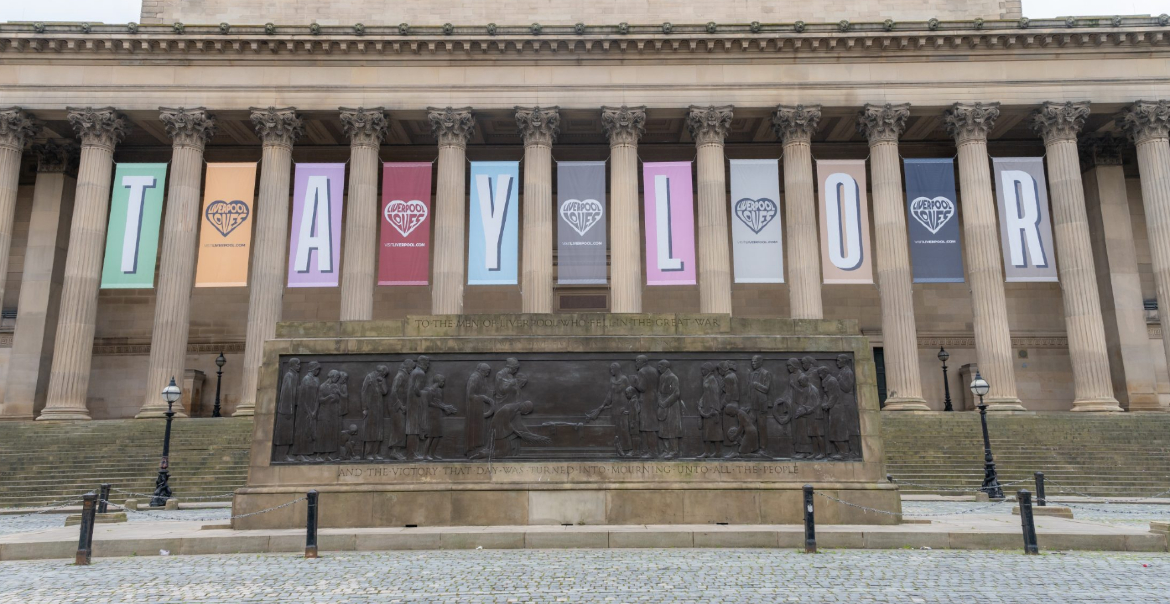 View of St George's Plateau, Liverpool with large colorful banners spelling "TAYLOR" between the columns.