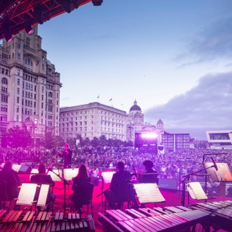 An image taken from the stage at an outdoor event with the crowd and Liveprool iconic buildings in the background.
