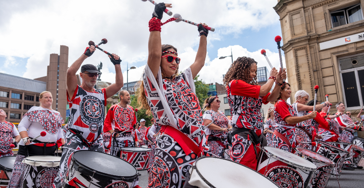 A street performance of drummers at an outdoor celebration