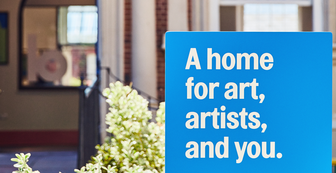 An image of the exterior of Bluecoat with a blue sign reading " A home for art, artists and you."