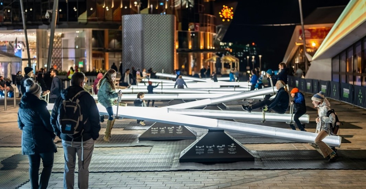 An interactive light installation of see-saws with lots of people interacting with them.