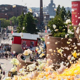 An explosion of colourful foam on Sugar House Steps, Liverpool ONE on a sunny day.