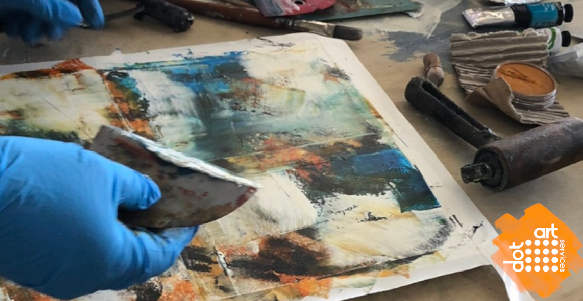 A close-up image of someone wearing a blue glove working on an oil painting.