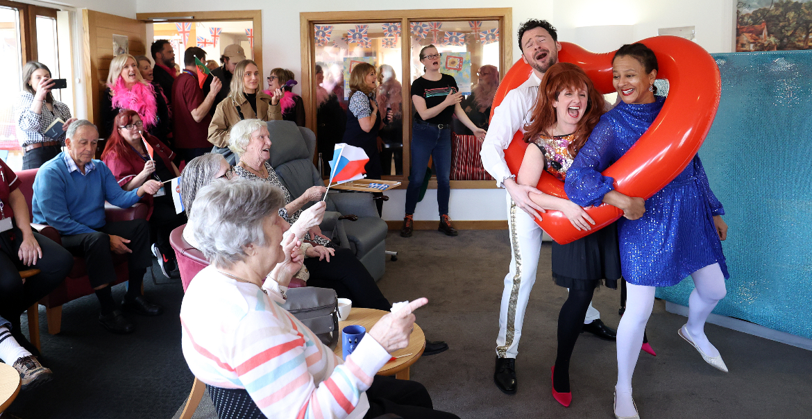 A small performance taking place in a care home with an engaged audience